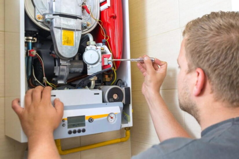 Мастер ремонтирует газовую колонку